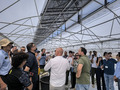 A group of people standing in a greenhouse.