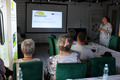 Group of people sitting in a conference room watching a presentation.