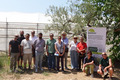 Picture of a group standing outside in front of a greenhouse.