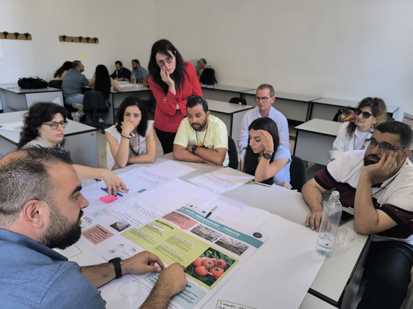 A group of people sitting on a table discussing.