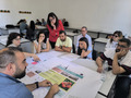 A group of people sitting on a table discussing.