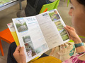 A person holding a leaflet with informations on it.