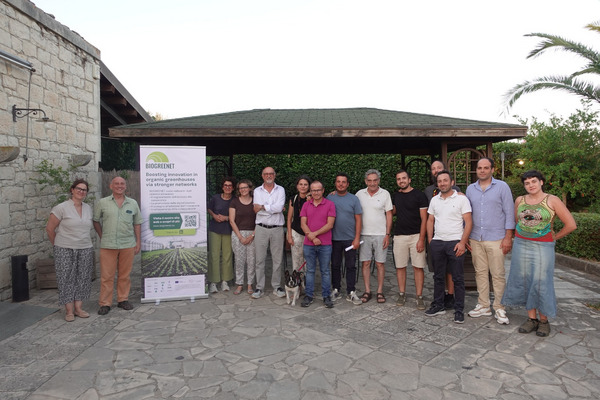 Group photo with roll up of Biogreenet in front of a house.